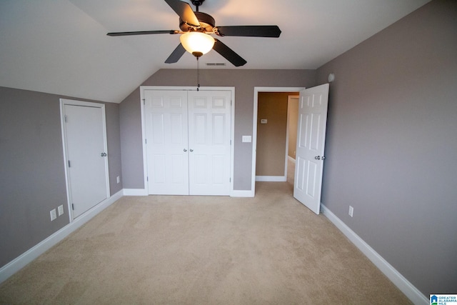 unfurnished bedroom with a closet, light colored carpet, and baseboards