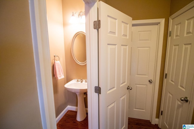 bathroom with baseboards and wood finished floors