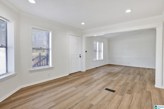 spare room with light wood-style floors, baseboards, and ornamental molding