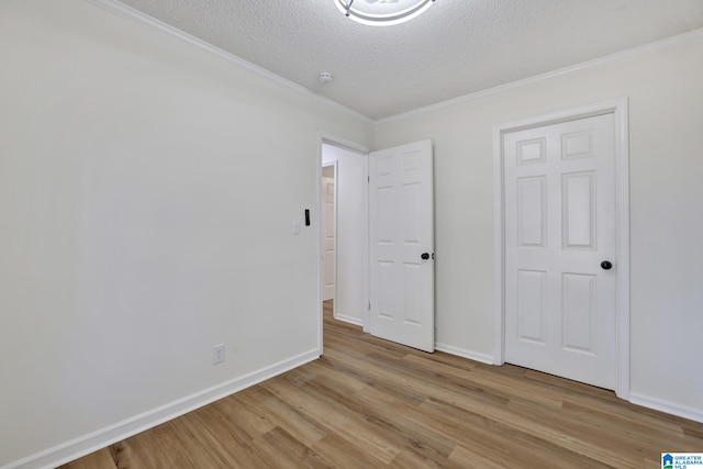 unfurnished bedroom with crown molding, light wood-style flooring, baseboards, and a textured ceiling