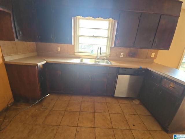 kitchen with a sink, dishwasher, light tile patterned floors, and light countertops