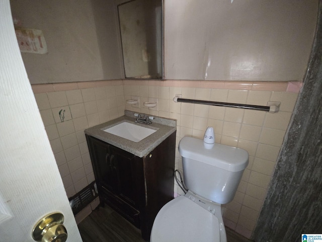 bathroom with a wainscoted wall, toilet, and vanity