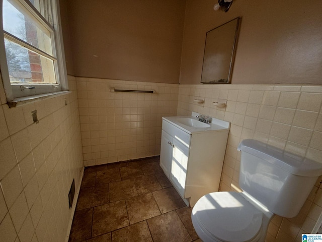 half bathroom with a wainscoted wall, toilet, and vanity