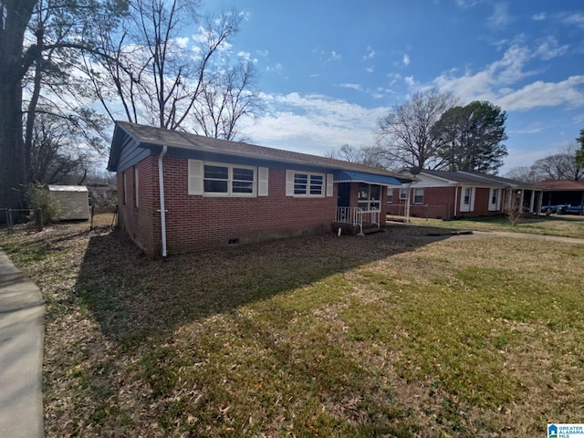 view of front of house with crawl space, a front yard, and brick siding