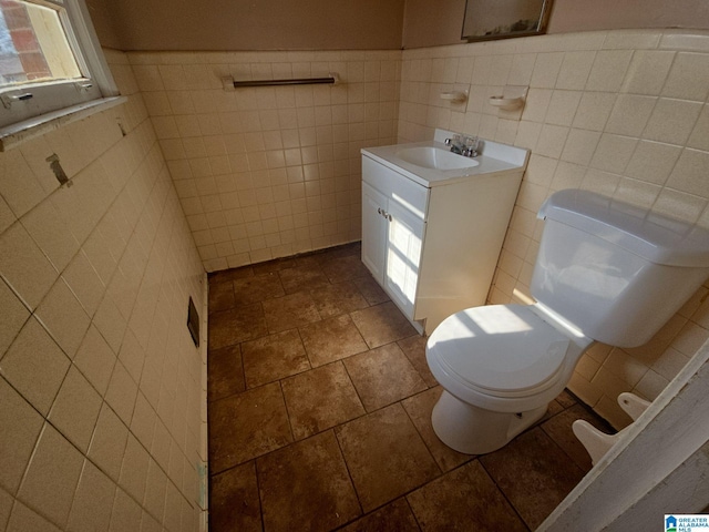 bathroom with toilet, wainscoting, and vanity