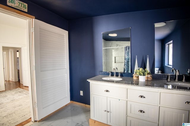 bathroom featuring double vanity, marble finish floor, curtained shower, and a sink