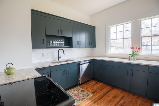 kitchen with backsplash, dishwasher, range with electric stovetop, wood finished floors, and a sink