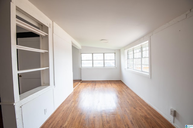 empty room with lofted ceiling and wood finished floors