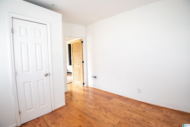 unfurnished room featuring light wood-style flooring, visible vents, and baseboards