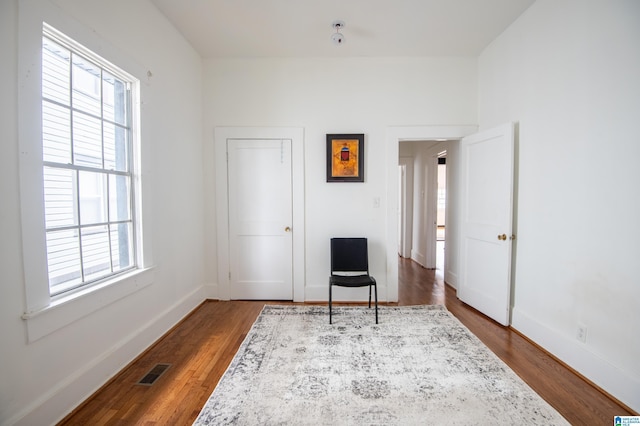 sitting room with visible vents, baseboards, and dark wood-style flooring