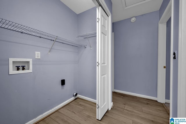 clothes washing area with hookup for a washing machine, baseboards, and wood finished floors