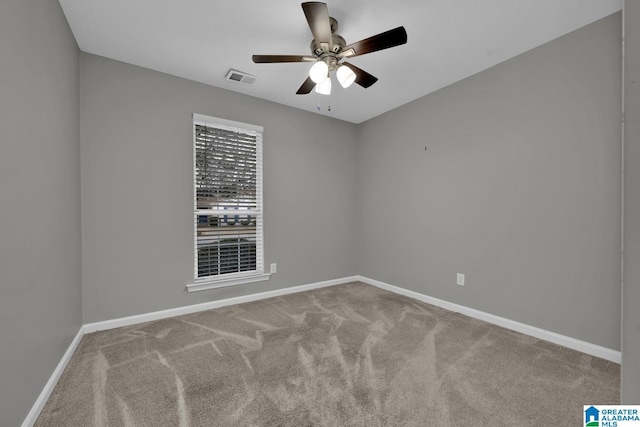 unfurnished room featuring carpet flooring, baseboards, visible vents, and ceiling fan