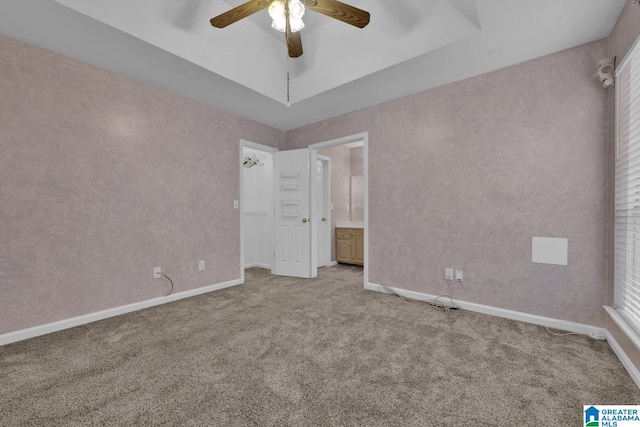 unfurnished bedroom featuring light carpet, a ceiling fan, ensuite bath, and baseboards