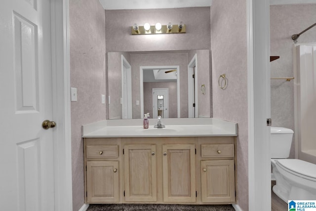 full bathroom with a shower, toilet, vanity, and wallpapered walls