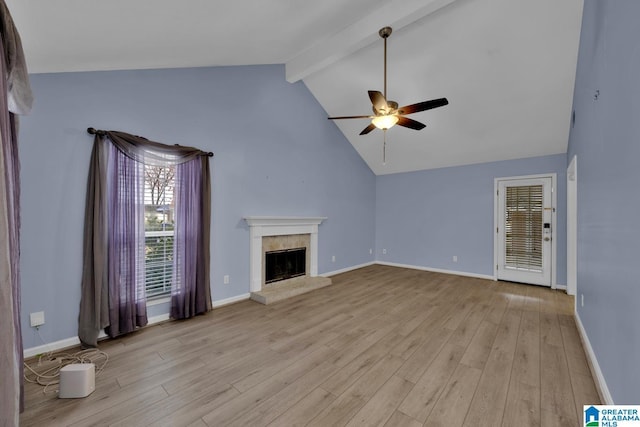 unfurnished living room featuring a ceiling fan, baseboards, light wood finished floors, vaulted ceiling with beams, and a fireplace with raised hearth