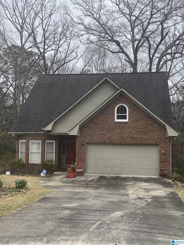 view of front of property with aphalt driveway, a garage, and brick siding