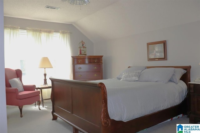 bedroom with visible vents, lofted ceiling, and carpet floors