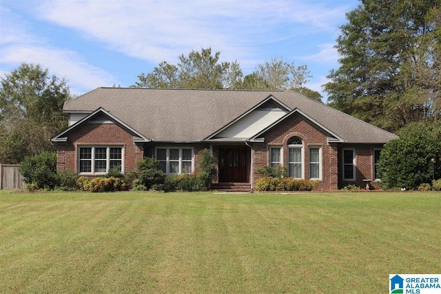 view of front facade with brick siding and a front yard