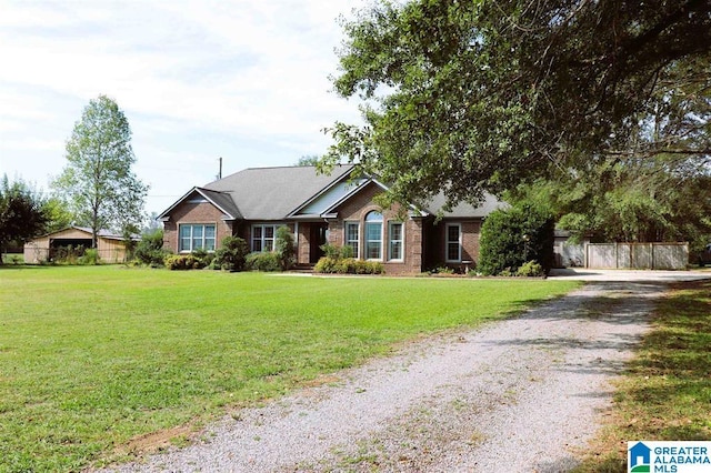 ranch-style house featuring brick siding, a front lawn, and driveway