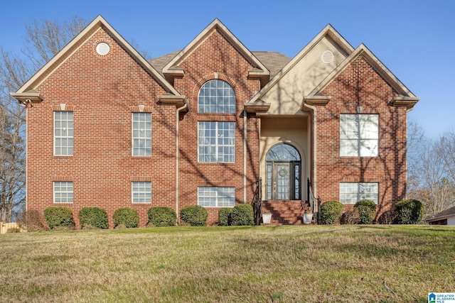 view of front facade with a front lawn, french doors, and brick siding