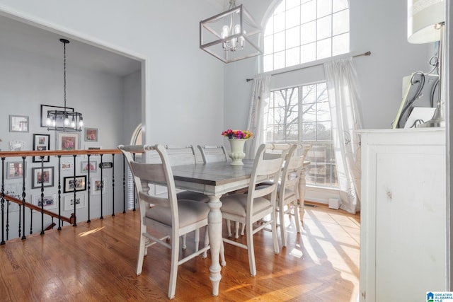 dining area featuring an inviting chandelier, a high ceiling, and wood finished floors