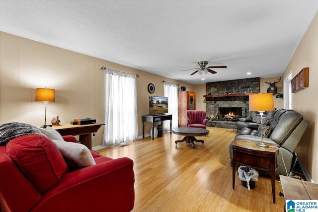236 Oak Ridge Dr, Oneonta, AL 35121 - living area featuring a ceiling fan, a stone fireplace, a textured ceiling, and wood finished floors
