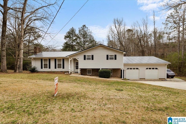 236 Oak Ridge Dr, Oneonta, AL 35121 - tri-level home with metal roof, a chimney, a garage, concrete driveway, and a front yard