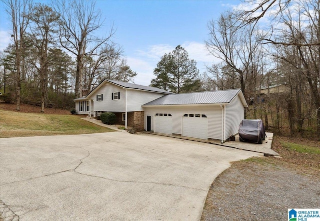 236 Oak Ridge Dr, Oneonta, AL 35121 - view of front of home with concrete driveway, metal roof, an attached garage, and a front lawn