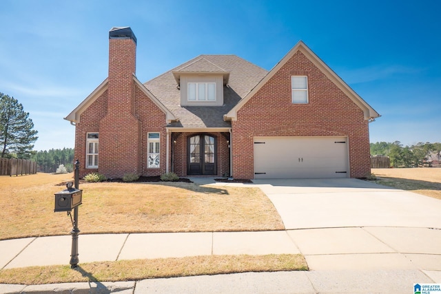 view of front facade featuring french doors, concrete driveway, a front yard, a shingled roof, and brick siding