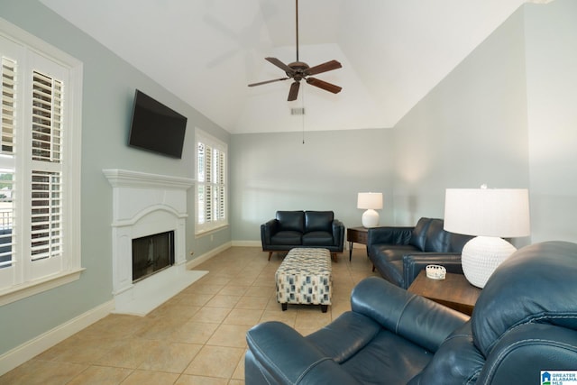 living area featuring light tile patterned floors, baseboards, ceiling fan, and vaulted ceiling