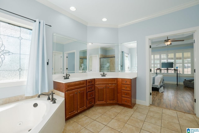 ensuite bathroom with plenty of natural light, a jetted tub, ornamental molding, and a ceiling fan