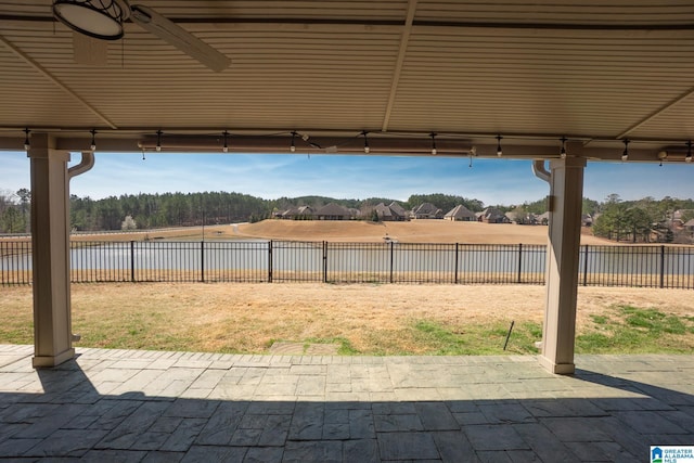 view of patio with a fenced backyard, a water view, and ceiling fan