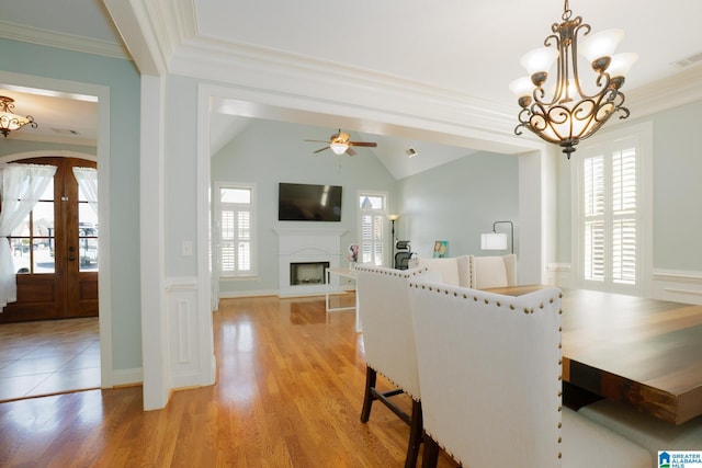 dining area featuring visible vents, light wood-style floors, crown molding, and vaulted ceiling