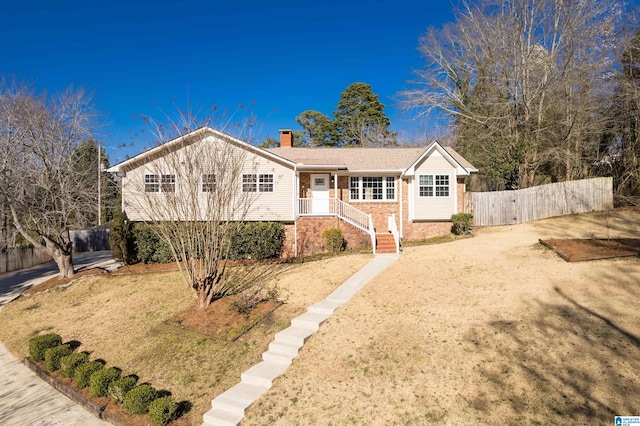 ranch-style house featuring fence, brick siding, and a chimney