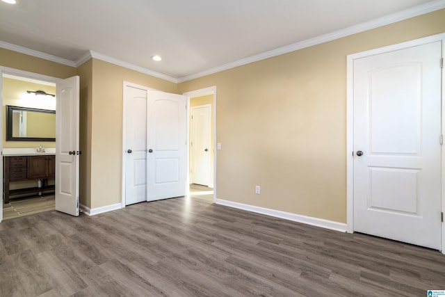 unfurnished bedroom with baseboards, wood finished floors, and ornamental molding