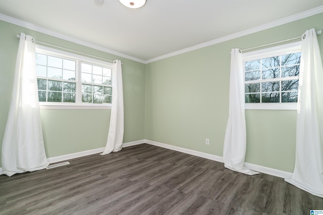 spare room with crown molding, dark wood-style floors, baseboards, and a wealth of natural light