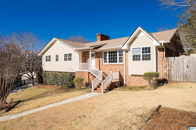 ranch-style home with fence, brick siding, and a chimney