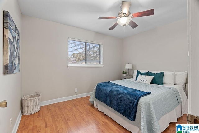 bedroom with a ceiling fan, wood finished floors, and baseboards