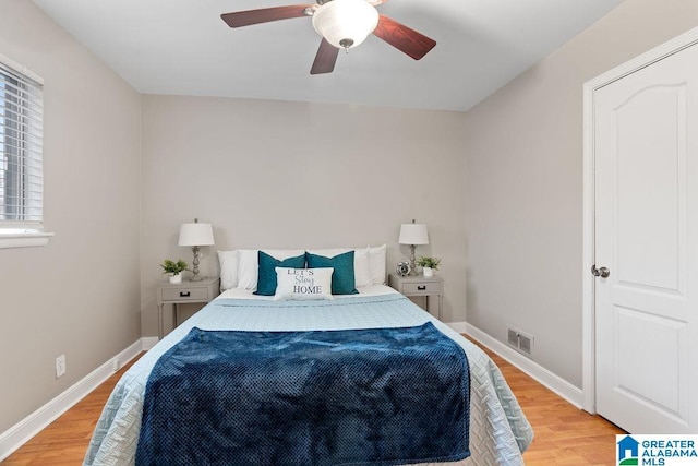 bedroom with light wood-style flooring, baseboards, visible vents, and ceiling fan