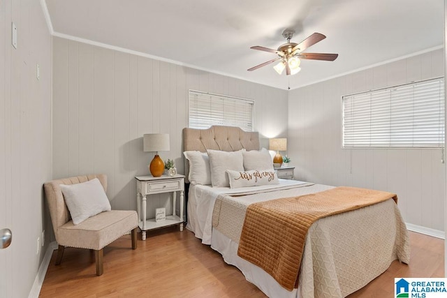 bedroom featuring ceiling fan, baseboards, light wood-style flooring, and ornamental molding