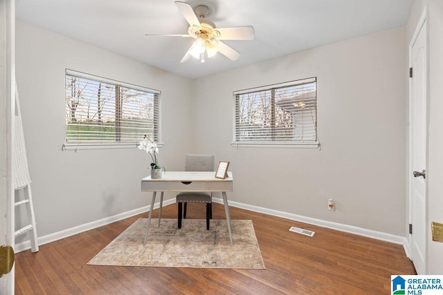 office space featuring ceiling fan, wood finished floors, visible vents, and baseboards