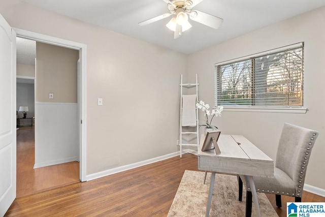 office area featuring baseboards, a ceiling fan, and wood finished floors