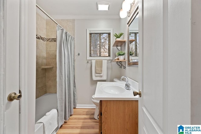 bathroom with ornamental molding, wood finished floors, shower / tub combo, baseboards, and vanity