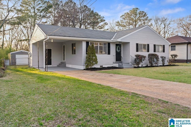 ranch-style home with an outbuilding, driveway, a front yard, crawl space, and a carport