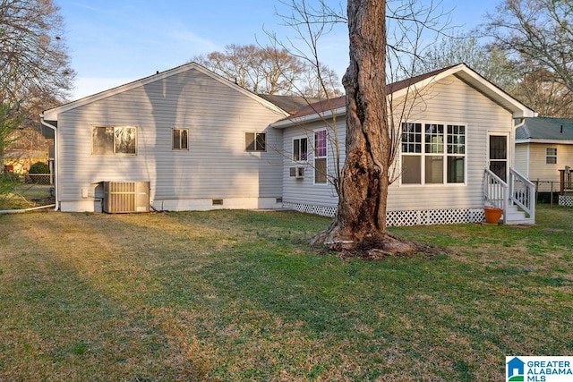 rear view of property featuring crawl space, central air condition unit, a yard, and entry steps