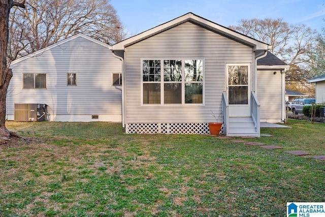 back of property with crawl space, central air condition unit, a lawn, and entry steps