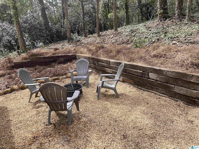 view of yard featuring a view of trees and a fire pit