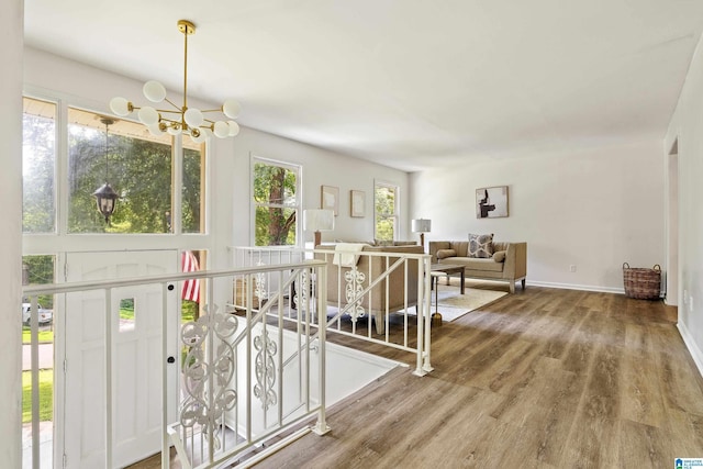 entrance foyer with a notable chandelier, baseboards, and wood finished floors