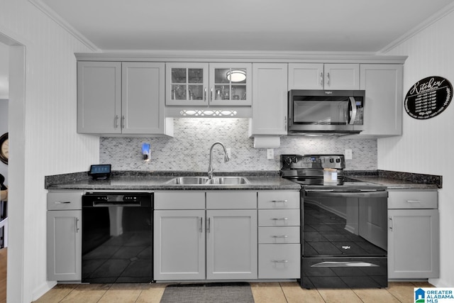 kitchen featuring a sink, black appliances, ornamental molding, and light tile patterned floors