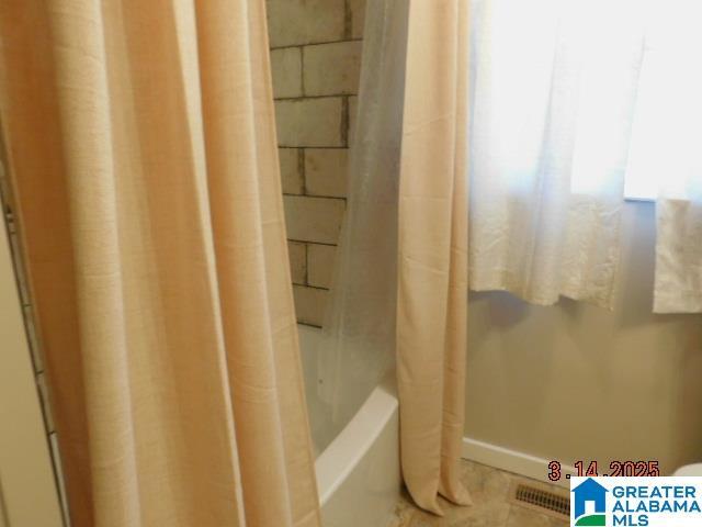 bathroom featuring shower / bath combo with shower curtain